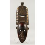 A LONG NATIVE CARVED WOOD FACE MASK with diamond inlaid head pieces. 70cms long.