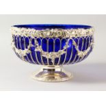 A PIERCED CIRCULAR PLATED ROSE BOWL with sapphire blue liner. 28cms diameter.