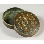 A SMALL CHINESE CIRCULAR BRONZE BOX AND COVER, with calligraphy inscription. 7.5cms diameter.
