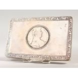A CONTINENTAL SILVER SNUFF BOX, the lid inset with a Thaler. 12cms long.