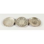 THREE CHINESE WHITE METAL COIN DISHES. 9.5cms and 10cms diameter.