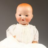 AN ARMAND MARSEILLE "DREAM BABY" PORCELAIN DOLL, A.M. 351, wearing a lace christening gown. 32cms