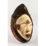 A TRIBAL CARVED WOOD MASK WITH WHITE PIGMENT. 30CMS LONG.