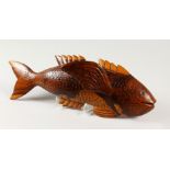 A PITCAIRN ISLAND CARVED WOOD FLYING FISH by JOHN CHRISTIAN. Signed. 40cms long.