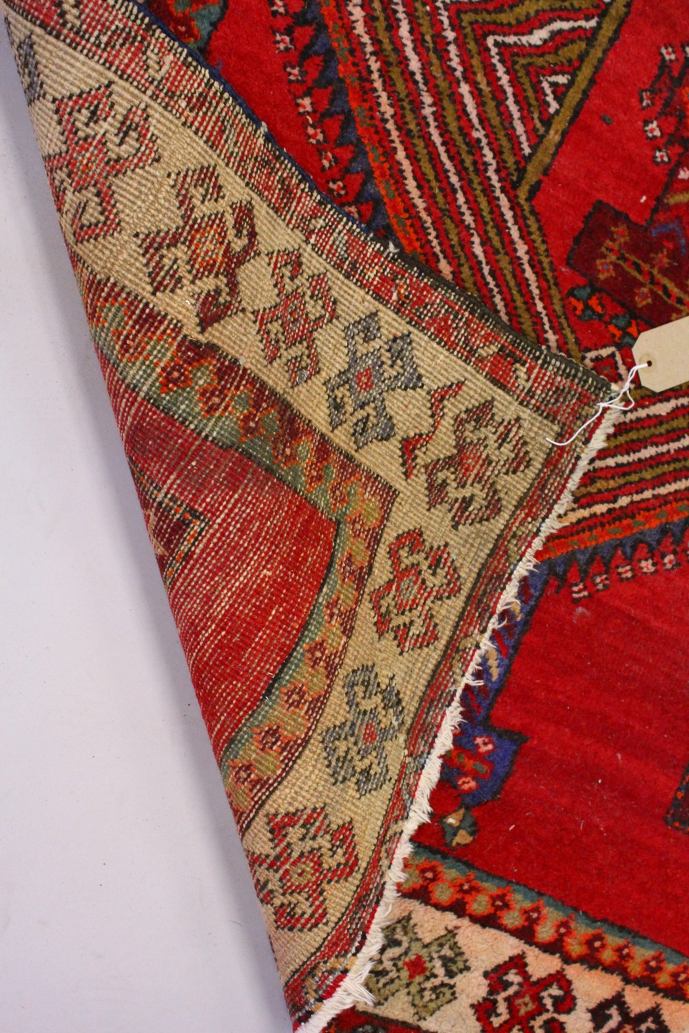 A PERSIAN LONG CARPET / RUNNER, bright red ground with three blue ground motifs in a stylized - Image 7 of 8