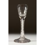 A GEORGIAN WINE GLASS with fluted bowl and white opaque twist stem. 15cms high.