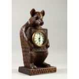 A BLACK FOREST STYLE CARVED BEAR CLOCK. 30cms high.
