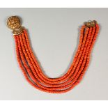 A CORAL NECKLACE, with ornate gold clasp.
