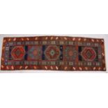 A PERSIAN RUNNER, with five large motifs in a stylized double border. 330cms x 104cms.