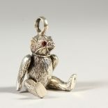 AN ARTICULATED SILVER TEDDY BEAR PENDANT. 5cms high.