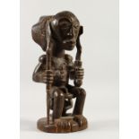 A GOOD NATIVE CARVED WOOD CEREMONIAL SEATED FIGURE. 36cms high.