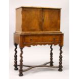 AN 18TH CENTURY CONTINENTAL WALNUT CABINET ON STAND, the upper section with two doors enclosing a