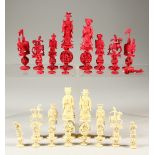 A RED AND WHITE STAINED IVORY CHESS SET.