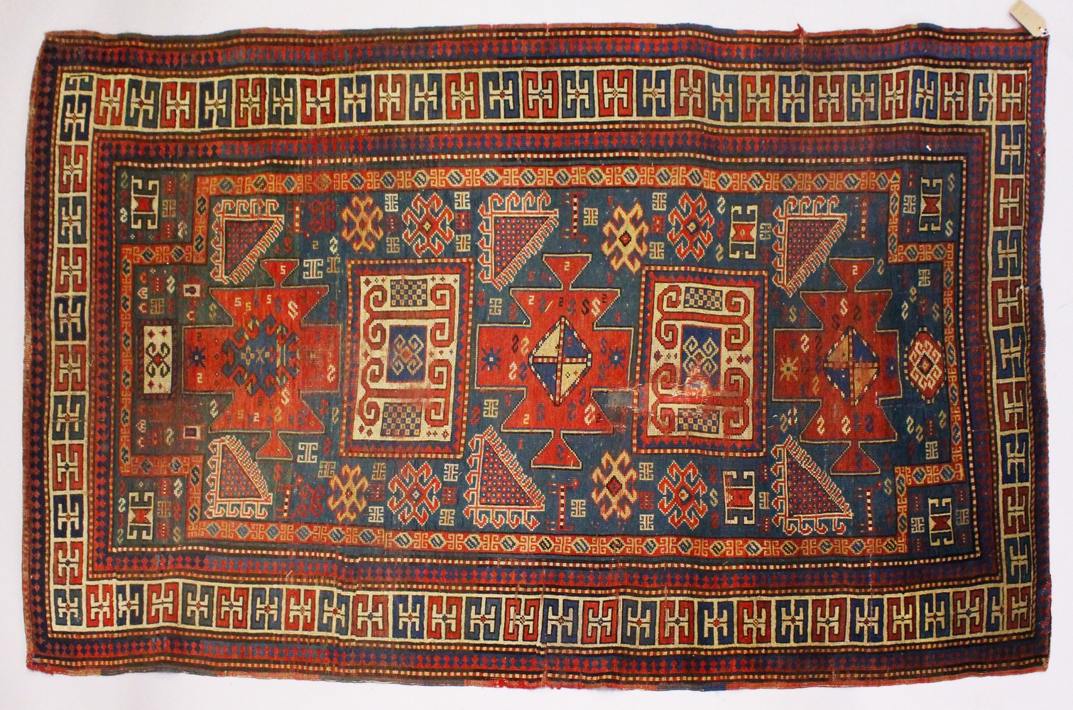 A PERSIAN RUG, pale blue ground with geometric panels, with a similar border. 250cms x 142cms,