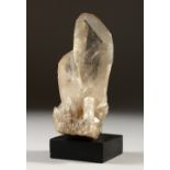 A QUARTZ ROCK CRYSTAL SPECIMEN on a wooden base. 13cms high.