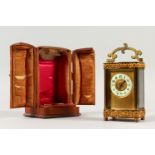 A 19TH CENTURY FRENCH BRASS SERPENTINE SHAPED CARRIAGE CLOCK. 12cms high, in a folding leather