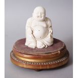 A 19TH CENTURY CHINESE CARVED IVORY BUDDHA ON STAND, the buddha seated upon a later french wooden