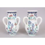 A PAIR OF IZNIK STYLE POTTERY THREE HANDLED VASES, 25cm high.