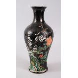 A CHINESE ENAMELLED FAMILLE NOIR PORCELAIN VASE, decorated upon a black ground with scenes of