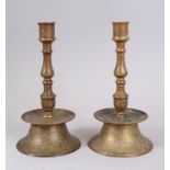 A PAIR OF POSSIBLY 16TH-17TH CENTURY OTTOMAN BRASS CANDLESTICKS with Armorial design, 26cm high.