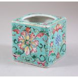 A CHINESE MARK AND PERIOD TURQUOISE GROUND FAMILLE ROSE BRUSH POT, decorated with formal flora and