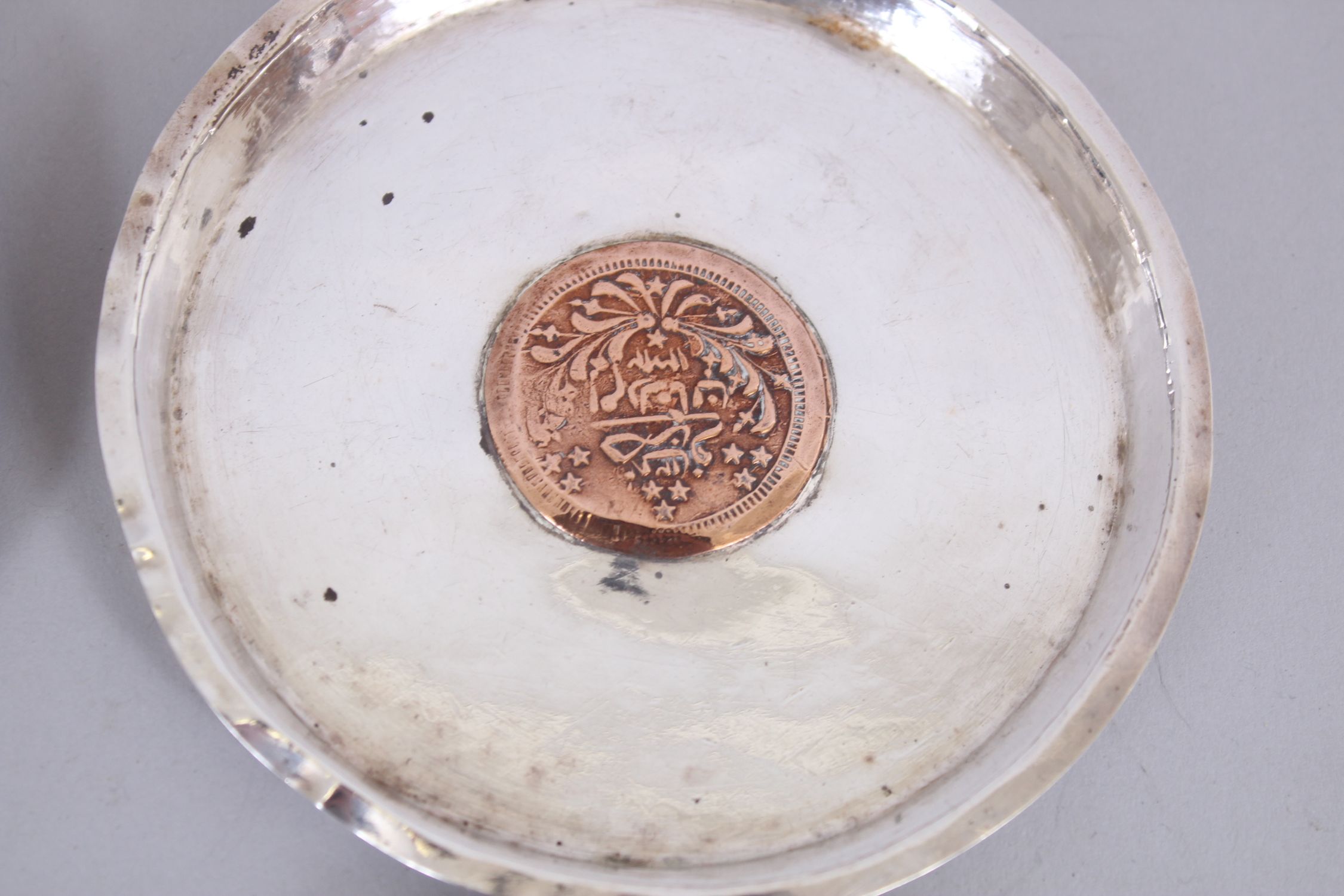 A SET OF FOUR ISLAMIC SILVER CIRCULAR DISHES inserted with coins, 11cm diameter. - Image 3 of 6