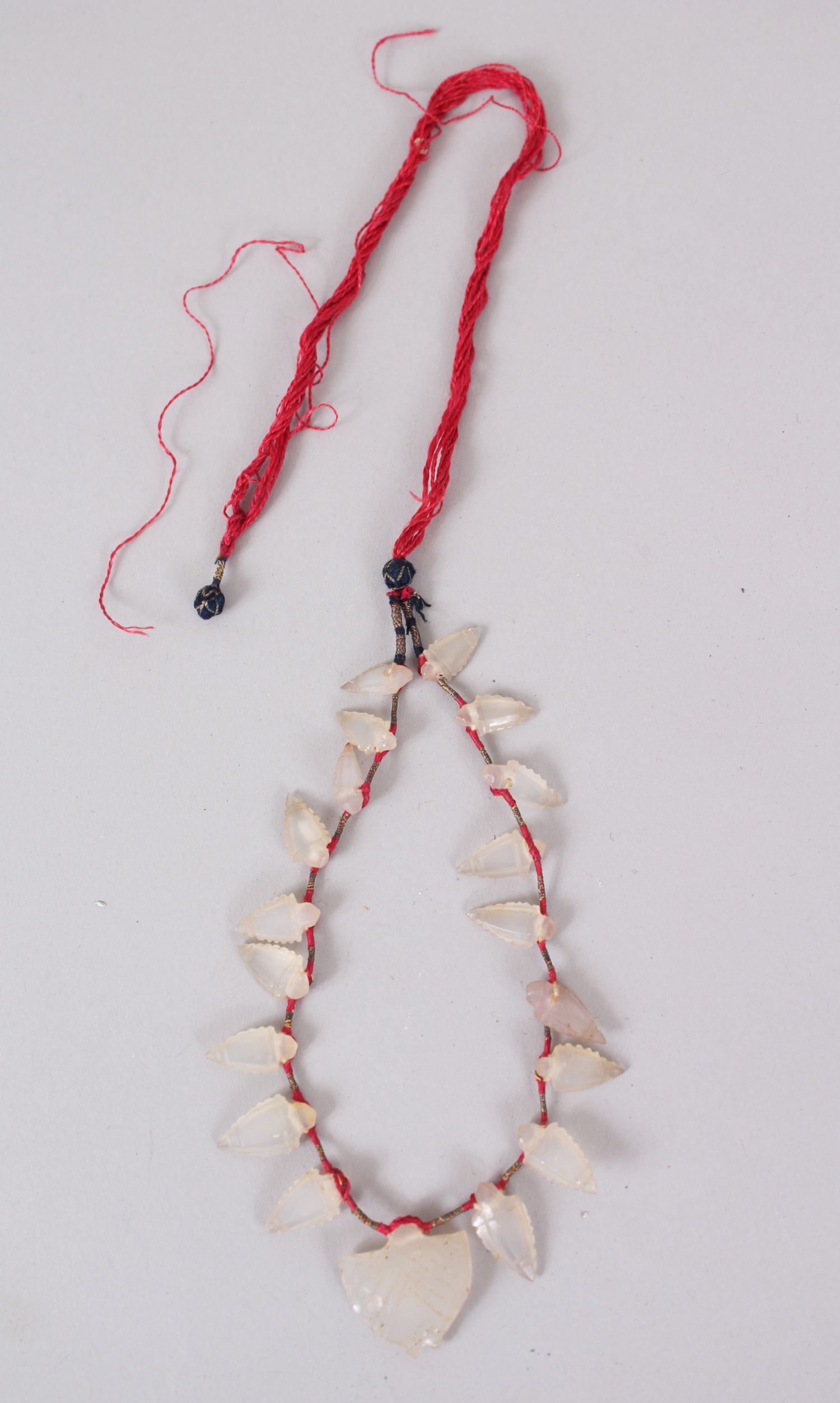 AN ISLAMIC CORNELIAN WHITE ARROW HEAD NECKLACE, 30cm long.