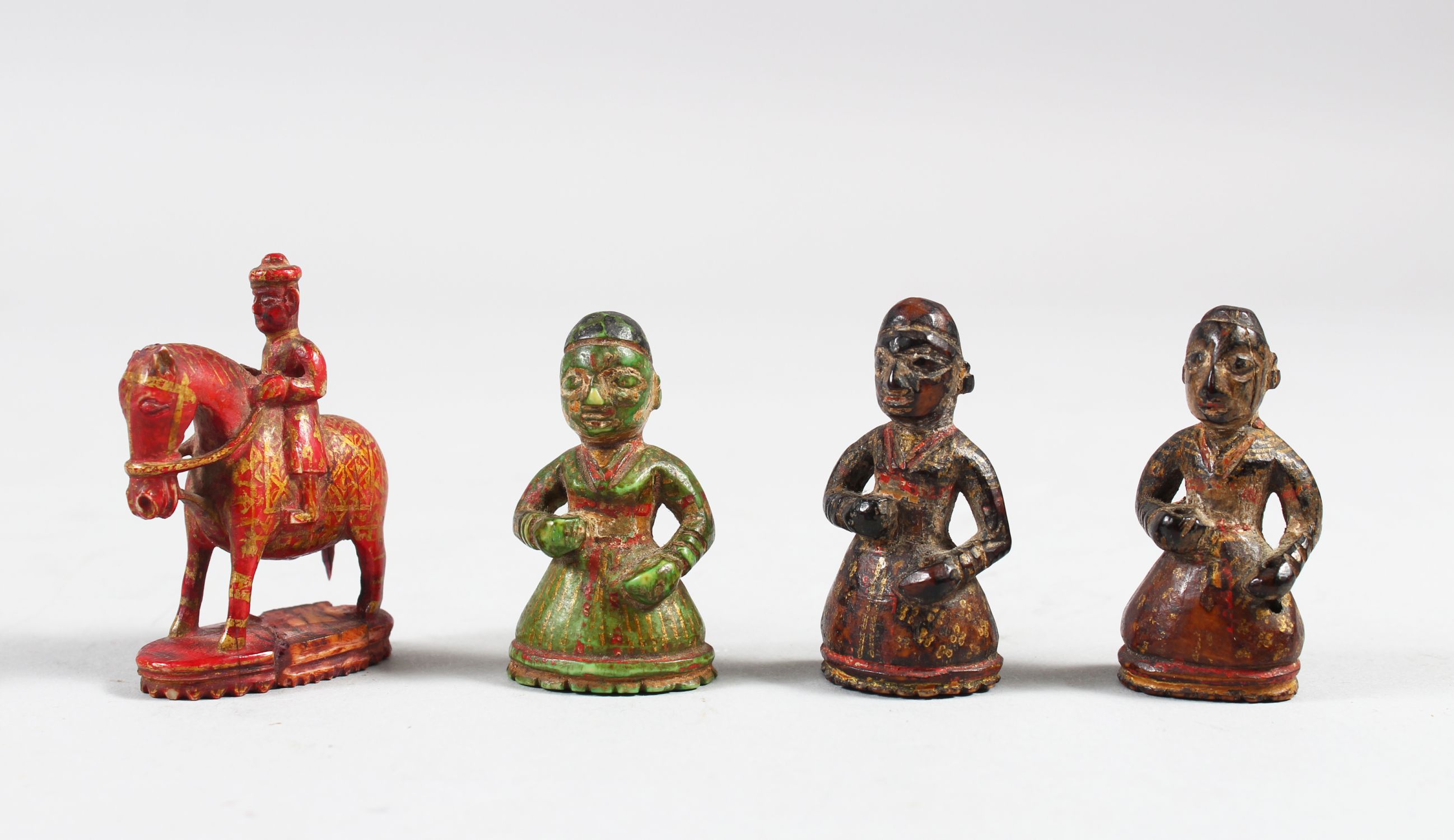 A COLLECTION OF FOUR 17TH CENTURY INDIAN POYCHROME IVORY CHESS PIECES, 5cm high.