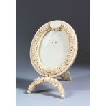 AN 18TH-19TH CENTURY SRI LANKAN CARVED IVORY OVAL EASEL MINIATURE FRAME, 15cm high, 10cm wide.