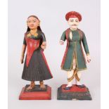 A RARE PAIR OF 19TH CENTURY INDIAN CARVED WOOD AND PAINTED FIGURES of a man and woman on stepped