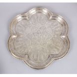A PERSIAN WHITE METAL SHAPED TRAY engraved with trees and figures, 34cm diameter.