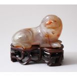 A 19TH CENTURY CHINESE AGATE CARVED FIGURE OF A DOG & HARDWOOD STAND, the agate dog measures 5cm