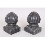 A PAIR OF MOGUL INDIAN CARVED STONE CARPET WEIGHTS on square bases, 16cm high.