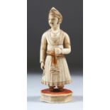 AN EARLY 19TH CENTURY INDIAN POLYCHROME CARVED IVORY FIGURE of a Ruler standing on an octagonal