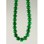 A GOOD CHINESE SPINACH GREEN JADE BEAD NECKLACE, comprising of 74 spherical jade beads, measuring