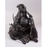 A JAPANESE MEIJI PERIOD BRONZE OKIMONO OF JUROJIN & DEER, he is in a seated position with his head