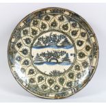 A 17TH-18TH CENTURY PERSIAN SAFAVID POTTERY GLAZED CIRCULAR DISH, the centre with flowers and