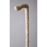 A GOOD 19TH CENTURY CHINESE CARVED IVORY PARASOL HANDLE, the main body carved in relief with