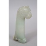 A CHINESE CARVED JADE SWORD HANDLE IN THE FORM OF A LION, 12cm high x 5 cm wide.