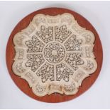 A 19TH CENTURY INDIAN CARVED AND PIERCED CIRCULAR STONE DISH, in later wooden frame, dish 32cm