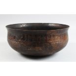 AN ISLAMIC PERSIAN HAND CHASED BRASS BOWL, with Kufic calligraphy, 26cm diameter.