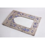 AN ISLAMIC MIDDLE EASTEN EMBOSSED SILVER AND BLUE ENAMEL MIRROR, 32cm high, 22cm wide.