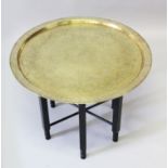 A 19TH-20TH CENTURY CAIROWARE HAND CHISELLED BRASS CIRCULAR TRAY on wooden stand, 65cm diameter.