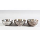 THREE PERSIAN WHITE METAL CIRCULAR BOWLS with chased borders, 10cm diameters.