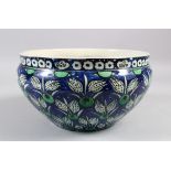 A 19TH CENTURY IZNIK STYLE POTTERY CIRCULAR BOWL, the sides with blue ground and flower heads,