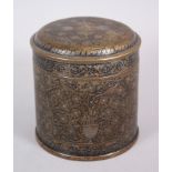 A GOOD INDIAN INLAID BRASS CIRCULAR BOX AND COVER with peacock design, 14cm high, 13cm diameter.