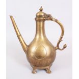 AN 18TH CENTURY MOGHUL INDIAN BRASS ENGRAVED EWER AND COVER, with long spout on four pod feet,