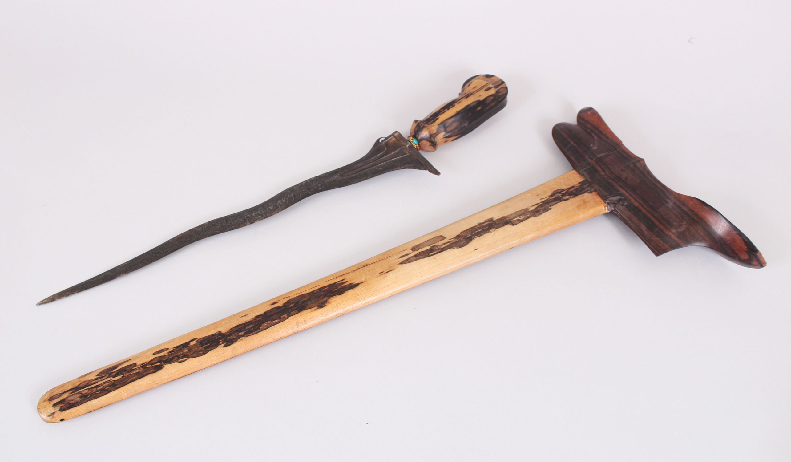 AN INDONISIAN KRIS with wooden sheath, 67cm long.