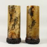 A GOOD PAIR OF CHINESE SPINACH GREEN JADE VASES & HARDWOOD STANDS, the cylindrical jade pots with