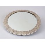 AN INDIAN SILVER CIRCULAR SHAPED MIRROR, the back with eight panels of flowers and a bird, 29cm